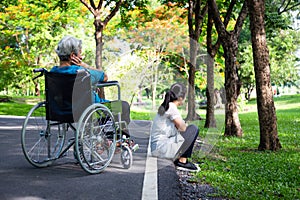 Asian adult woman touchy and angry acting with elderly people in wheelchair after senior mother argument,argue with daughter in