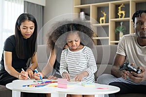 Asian-African American family relaxing, chatting, painting and having fun on vacation