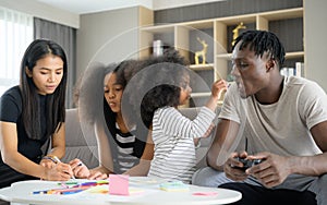 Asian-African American family relaxing, chatting, painting and having fun on vacation