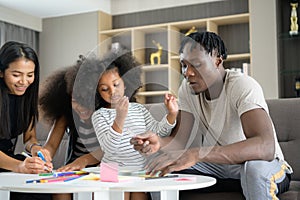 Asian-African American family relaxing, chatting, painting and having fun on vacation