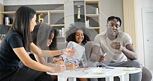 Asian-African American family relaxing, chatting, painting and having fun on vacation