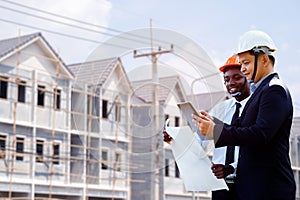 Asian and African architect engineer two expertise team plan with a building in background