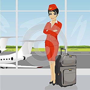 Asian air hostess posing with luggage in front of an airport observation deck