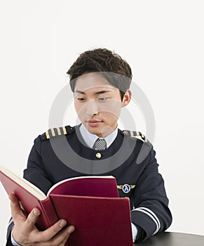 Asian Airline pilot reading a book