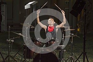 Asian American mixed teenager playing drums at home garden . cool and handsome young boy practicing on drum kit rehearsing