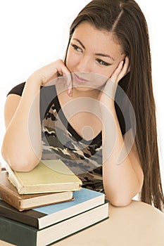 Asian American teen sitting at desk with school books