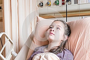 Asian American tween girl in hospital bed