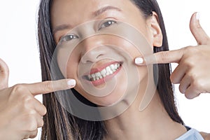 Asian American Woman pointing her perfect white Teeth