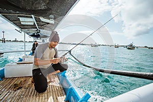 Asian angler checks the reel when leaving for fishing