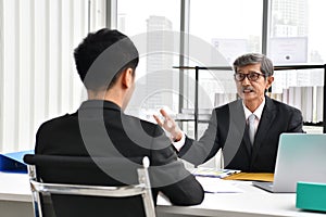 Asian angry boss yelling at employee, business concept