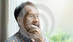 Asian angry mad face elderly serious old man looking at away while stroking the beard