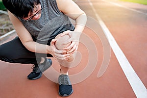 Asian athlete man suffering from knee pain