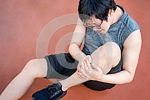 Asian athlete man suffering from leg and knee pain