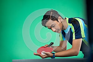 Asian athlete ready to serve during a ping pong match