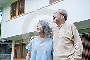 Asian atrractive Happy Senior couple stand outdoor in garden at home. Loving Elderly Older grandparent smile and hugging each