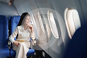 Asian attractive business woman passenger sitting on business class luxury plane while relax while travel concept