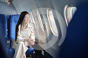 Asian attractive business woman passenger sitting on business class luxury plane while relax while travel concept