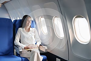 Asian attractive business woman passenger sitting on business class luxury plane while relax while travel concept