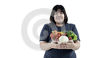 Asian attractive fat woman holding glass bowl  contains fruit and fresh vegetables