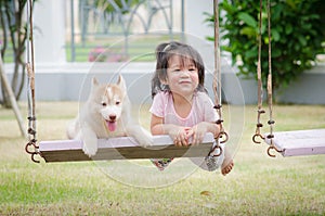 Asian baby baby on swing with puppy