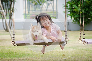 Asian baby baby on swing with puppy