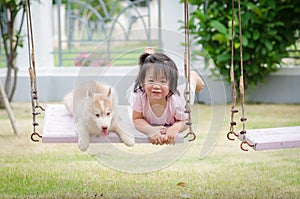 Asian baby baby on swing with puppy