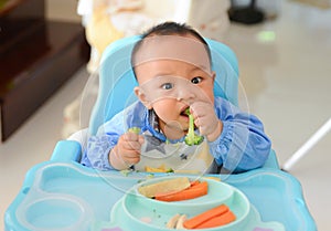 Asian baby boy 6 months old eating with Baby Led Weaning BLW method, Self-Feeding