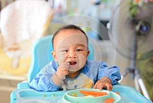 Asian baby boy 6 months old eating with Baby Led Weaning BLW method, Self-Feeding