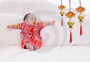 Asian baby boy Chinese Cheongsam costume toddler lie down on bed at home smiling laughing good humored  infant Chinese boy laugh