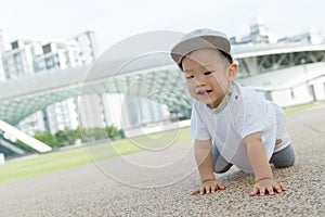 Asian baby boy crawling in park