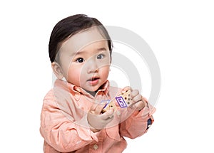 Asian baby boy holding wooden toy block