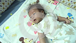 Asian baby boy lying on the bed and crying