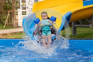 Asian baby boy and moter on water slide at aquapark