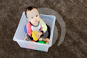 Asian baby boy playing inside the plastic box