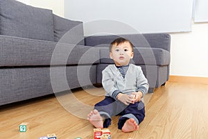 Asian baby boy sitting on floor and playing toy block