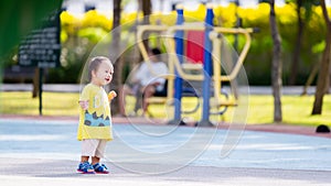 Asian baby boy standing smiling sweetly, little toddler showing joy when going for a walk in the park.