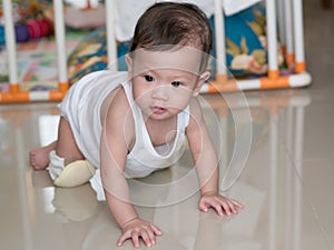 Asian baby crawling on floor in her house.