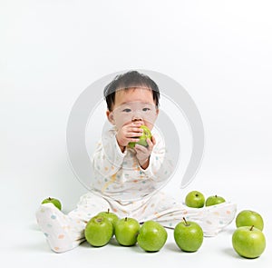 Asian baby eating green apple