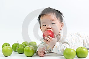 Asian baby eating red apple