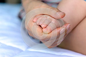 Asian baby feet in mother hands.