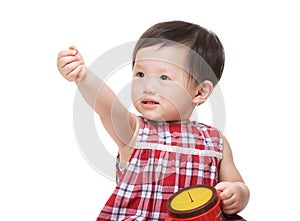 Asian baby girl holding snack box and hand up