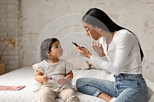 Asian Baby Girl Looking At Mommy Doing Makeup At Home