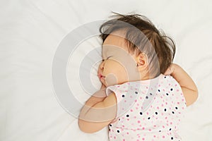 Asian baby girl sleeping on bed