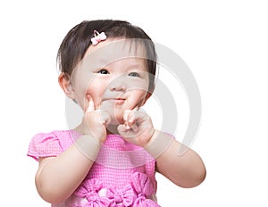 Asian baby girl two fingers touch her face