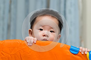 Asian baby in playpen