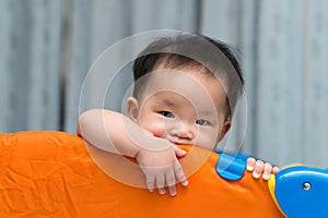 Asian baby in playpen