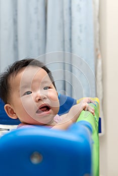 Asian baby in playpen