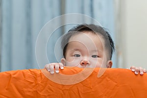 Asian baby in playpen
