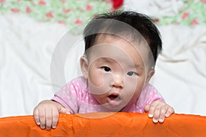 Asian baby in playpen
