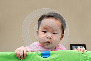 Asian baby in playpen